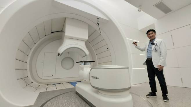 세브란스병원 방사선종양학과 홍채선 교수가 연세암병원 중입자치료센터 내 회전치료실을 보여주고 있다. 환자가 누우면 360도로 회전해 탄소를 조사할 수 있어 췌장암·간암·폐암 등 몸속 깊숙한 부위를 특정해 암세포만 공격할 수 있다./사진=정심교 기자