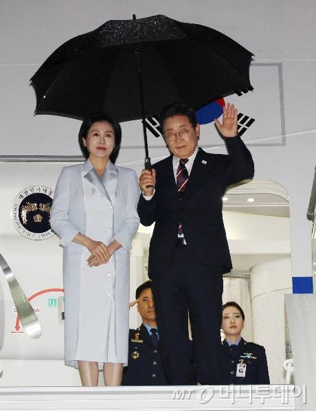 [캘거리=뉴시스] 최진석 기자 = 주요 7개국(G7) 정상회의 참석을 마친 이재명 대통령과 부인 김혜경 여사가 17일(현지 시간) 캐나다 앨버타주 캘거리국제공항에 도착해 공군 1호기에 탑승하며 손을 흔들고 있다. 2025.06.18. myjs@newsis.com /사진=