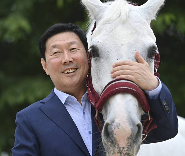 김영관 조교사가 지난 13일 경기 과천 렛츠런파크서울 경마장에서 한국마사회 소속 경주마와 다정한 포즈를 취하고 있다.  백동현 기자