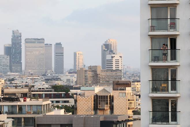17일(현지시간) 이스라엘 텔아비브에서 이란의 탄도 미사일 공격 위협이 계속되는 가운데 한 남성이 텔아비브 스카이라인이 내려다보이는 호텔 난간에 서 있다. [EPA]