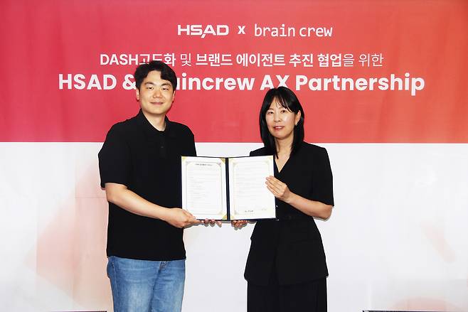 박애리(우측) HSAD 대표와 AI 솔루션 기업 브레인크루의 이경록 대표가 지난 16일 서울 마포 HSAD 본사에서 ‘대시(DASH) 고도화 및 브랜드 에이전트 추진 협업을 위한 업무 협약(MOU)’을 체결했다. [HSAD 제공]