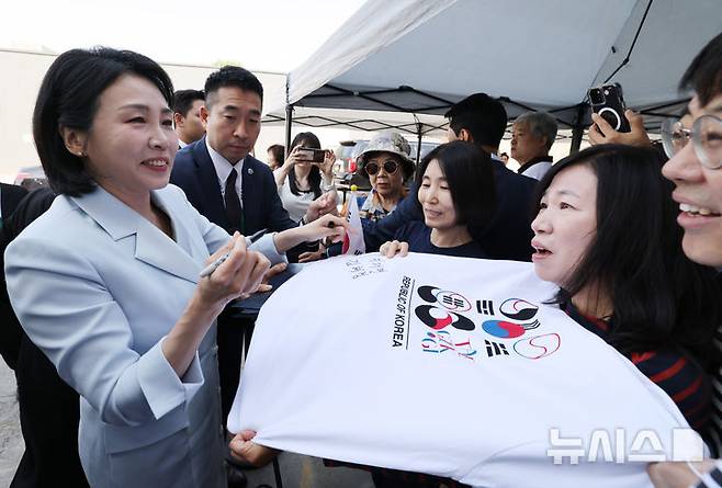 [캘거리=뉴시스] 최진석 기자 = 이재명 대통령 부인 김혜경 여사가 17일(현지 시간) 캐나다 앨버타주 캘거리 한인회관에서 열린 캐나다 서부 동포사회와의 대화를 나누기 전 인사하며 티셔츠에 싸인을 하고 있다. 2025.06.18. myjs@newsis.com