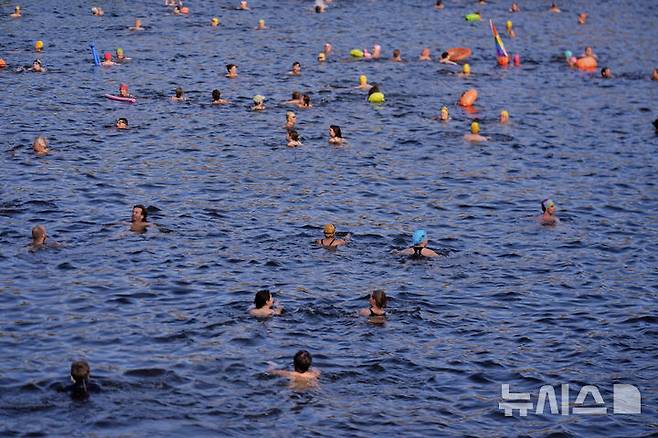 [베를린=AP/뉴시스] 17일(현지 시간) 독일 베를린 슈프레강에서 시민들이 수영 금지 해제를 촉구하며 수영하고 있다. 슈프레강은 수질 오염에 따른 보건 위험으로 100년 넘게 수영이 금지됐으며 강물과 분리된 부유식 수영장만 운영되고 있다. 시민 주도 비영리단체 '플루스바트 베를린'은 슈프레강이 수영할 만큼 수질이 개선됐다면서 수영 허용을 촉구하고 있다. 2025.06.18.