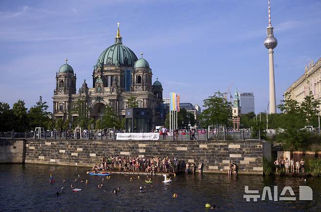 [베를린=AP/뉴시스] 17일(현지 시간) 독일 베를린 슈프레강에서 시민들이 수영 금지 해제를 촉구하며 수영하고 있다. 슈프레강은 수질 오염에 따른 보건 위험으로 100년 넘게 수영이 금지됐으며 강물과 분리된 부유식 수영장만 운영되고 있다. 시민 주도 비영리단체 '플루스바트 베를린'은 슈프레강이 수영할 만큼 수질이 개선됐다면서 수영 허용을 촉구하고 있다. 2025.06.18.