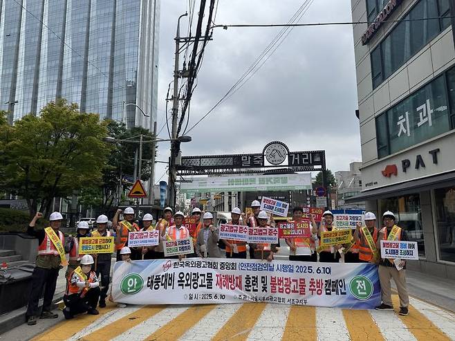 [서울=뉴시스] 서울 서초구가 지난 10일 양재 말죽거리 일대에서 안전한 옥외광고물 환경 조성을 위한 '2025년 옥외광고물 안전점검의 날' 행사를 개최하고 사진 촬영을 하고 있다. 2025.06.18 (사진 제공=서초구청) photo@newsis.com *재판매 및 DB 금지
