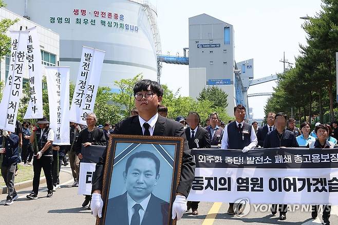 '생명ㆍ안전존중은 경영의 최우선 핵심가치' (태안=연합뉴스) 강수환 기자 = 태안화력발전소에서 작업하다 숨진 재하청 비정규직 노동자 고(故) 김충현 씨의 영결식이 18일 오전 충남 태안군 태안화력발전소에서 엄수된 뒤 김충현 노동자 사망사고 대책위와 유족들이 김씨가 일하던 한전KPS 태안사업처를 행진하고 있다. 김충현 씨는 지난 2일 오후 2시 30분께 태안화력 내 한전KPS 태안화력사업소 기계공작실에서 작업을 하다 공작기계에 끼이는 사고로 숨졌다. 2025.6.18 swan@yna.co.kr