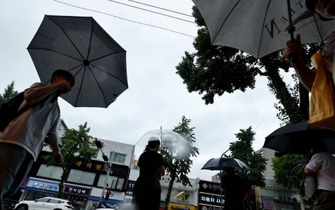 ▲ 지난해 8월21일 수원역 앞에서 시민들이 우산을 받쳐 쓰고 출근길에 나서고 있다. /김철빈기자 narodo@incheonilbo.com
