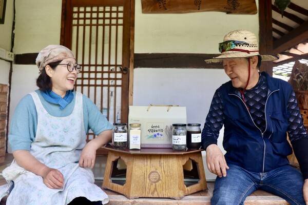 김걸환(사진 오른쪽)·권용순 부부가 고향사랑기부제 답례품으로 선정된 천성산약용도라지 가공식품을 보며 환하게 웃고 있다. /이현희 기자