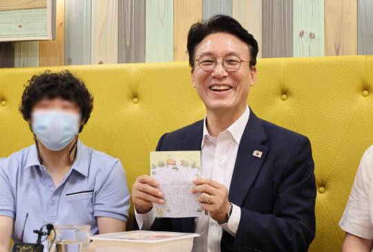 김민석 국무총리 후보자가 19일 서울 영등포구 꿈더하기 사회적협동조합에서 열린 발달장애인 일자리 현장 간담회에서 한 발달장애인으로부터 받은 편지를 들어보이고 있다. 연합뉴스