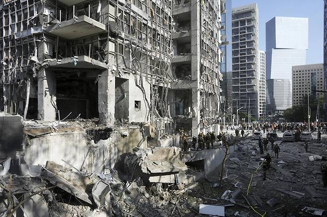 19일(현지 시간) 이스라엘 텔아비브 인근 라마트간에서 구조대와 군 관계자들이 이란의 미사일 직격 현장을 살피고 있다. 2025.06.19.라마트간=AP/뉴시스