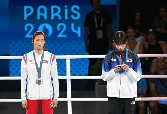 한국 여자 복싱 임애지(오른쪽)가 지난해 8월 프랑스 스타드 롤랑-가로스에서 열린 2024파리올림픽 여자 복싱 54kg급 시상식에서 자신이 획득한 동메달을 보고 있다. 왼쪽은 함께 동메달을 획득한 북한 방철미. 파리=서재훈 기자