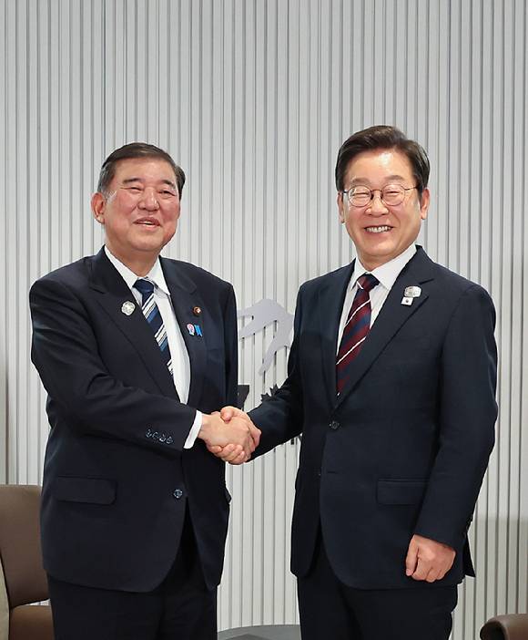 이재명 대통령이 지난 17일(현지시간) 캐나다 앨버타주 캐내내스키스 주요 7개국(G7) 정상회의장에서 열린 한일 정상회담에서 이시바 시게루 일본 총리와 악수하며 기념촬영을 하고 있다. [사진=연합뉴스]