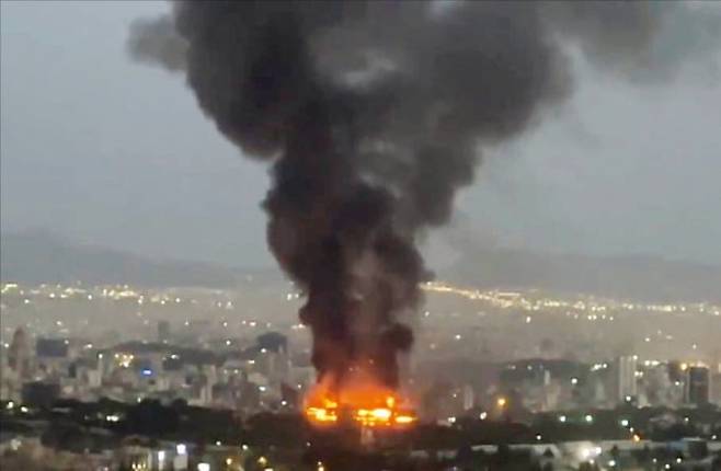 17일(현지시간) 이란 테헤란 도심에선 이스라엘의 미사일 공격으로 검은 화염과 불길이 치솟았다./ 사진= AFP·로이터연합뉴스