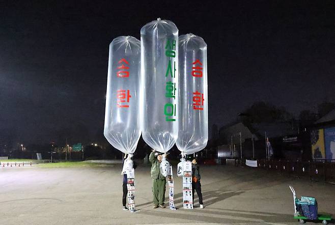 Members of the Families of Abductees to North Korea release eight anti-Pyongyang leaflets across the border from behind a fence at Peace Land in Paju, Gyeonggi, in the early hours of April 27. [NEWS1]