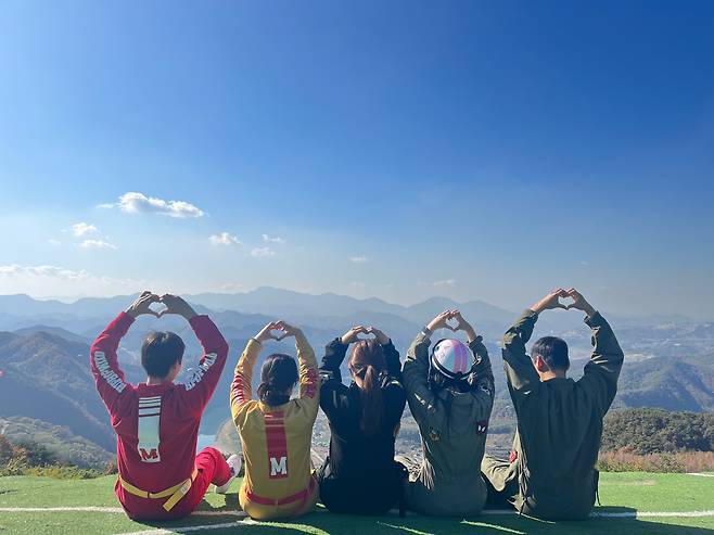 Travelers pose for a photo before boarding a paraglider during a package tour organized by the travel agency Jigu-noriter. [JIGU-NORITER]