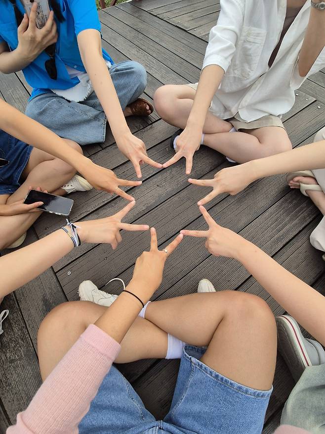 Participants in Jigu-noriter's package tour make a star with their fingers. [JIGU-NORITER]