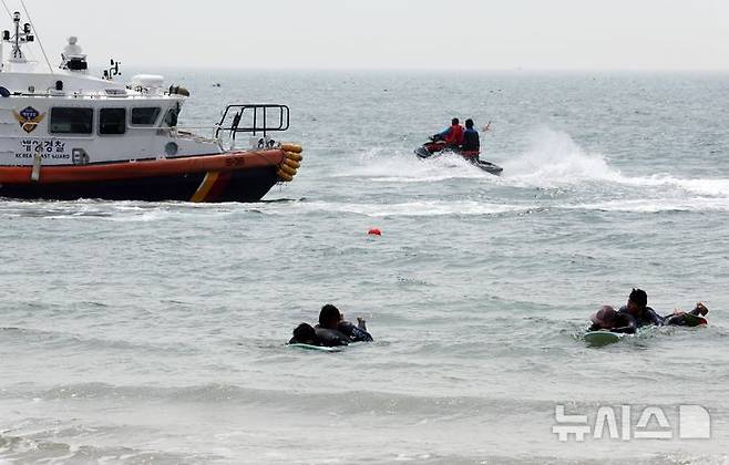 [부산=뉴시스] 하경민 기자 = 부산해경과 서프구조대 등이 19일 부산 해운대구 송정해수욕장에서 이안류 등으로 피서객이 먼 바다로 떠내려가는 상황을 가정한 합동 구조훈련을 하고 있다.부산지역 7개 해수욕장 중 해운대와 송정 해수욕장은 오는 21일 문을 열고, 광안리·송도·다대포·일광·임랑 등 나머지 5개 해수욕장은 오는 7월1일 일제히 개장한다. 2025.06.19. yulnetphoto@newsis.com
