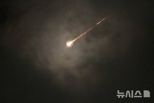 [예루살렘=AP/뉴시스]지난 16일(현지 시간) 예루살렘에서 이란의 미사일 발사에 따른 공습경보가 발령된 가운데 구름 사이로 발사체가 궤적을 그리며 비행하고 있다. 2025.06.19.