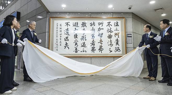 천대엽 법원행정처장(왼쪽부터 세번째) 등 내빈들이 19일 서울 마포구 서울서부지방법원에서 열린 통합관제센터 개소식 및 로비 작품 교체 행사에서 우봉 조재호 작가가 쓴 서예 작품을 제막하고 있다. ⓒ연합뉴스