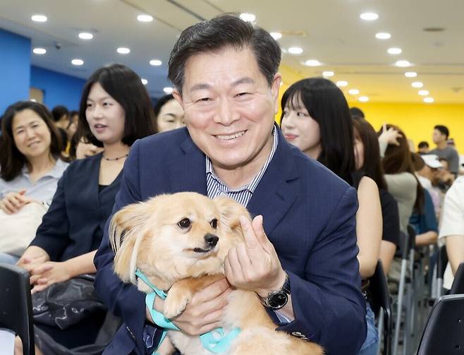 ▲ 박승원 광명시장이 지난 13일 광명시민회관 전시실에서 열린 반려동물 전시회에 참석해 입양 당일 새 가족을 만난 유기견 '룽지'를 품에 안고 입양의 의미를 알리는 기념사진을 촬영하고 있다. /사진제공=광명시