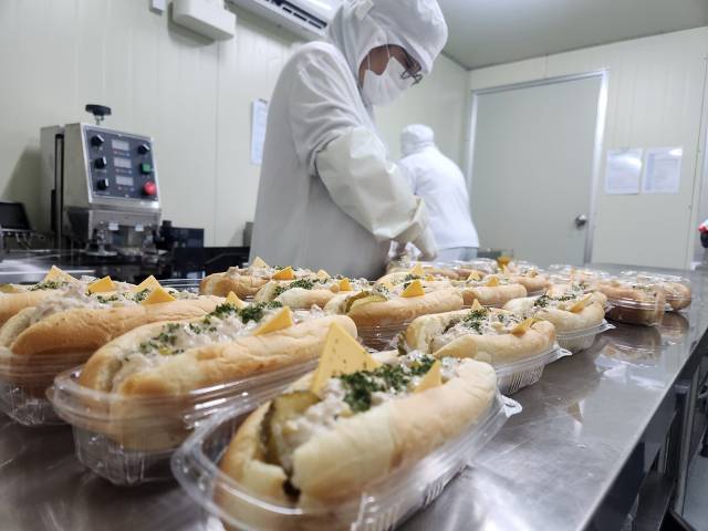 경남 밀양시 한 간편식 제조업체 관계자들이 19일 새벽부터 출근해 초동특별농공단지 내 기업체에 제공할 ‘노동자 천 원의 아침 식사’인 참치마요 핫도그를 만들고 있다. 강대한 기자