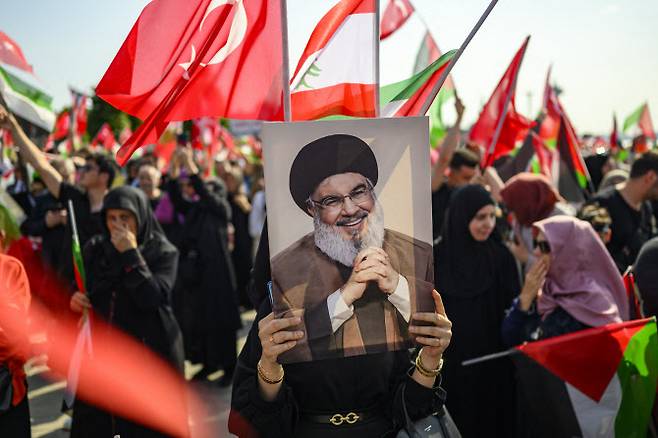 15일(현지시간) 튀르키예 이스탄불에서 열린 반(反)이스라엘 시위에서 한 여성이 지난해 이스라엘에 의해 제거된 헤즈볼라의 수장인 하산 나스랄라 사진을 들고 있다.(사진=AFP)