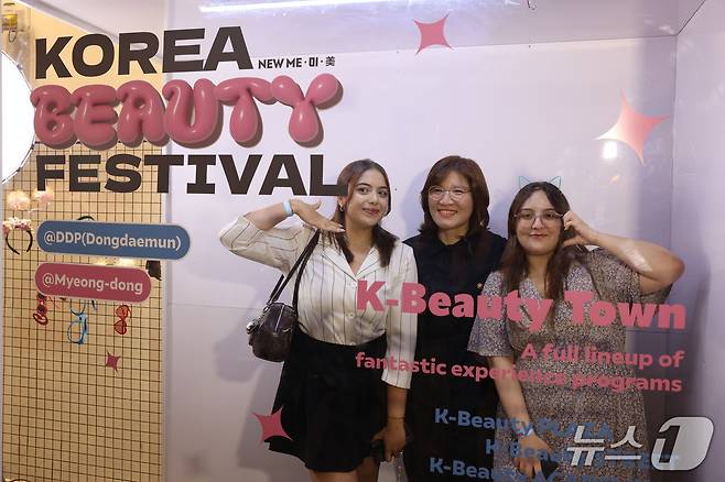 장미란 문화체육관광부 제2차관이 19일 서울 중구 동대문디자인플라자(DDP)에서 열린 코리아뷰티페스티벌 개막식 행사에 앞서 부스를 둘러보며 외국인 관람객과 기념촬영을 하고 있다.(문화체육관광부 제공)