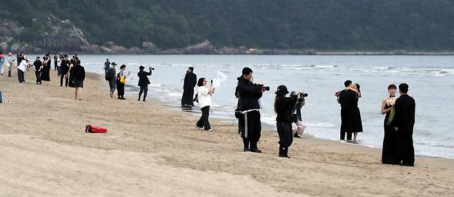 지난 12일 오후 부산 사하구 다대포해수욕장에 웨딩촬영을 하는 모든 예비 부부들이 검은색 드레스를 입고 웨딩사진을 찍고 있다./김동환 기자