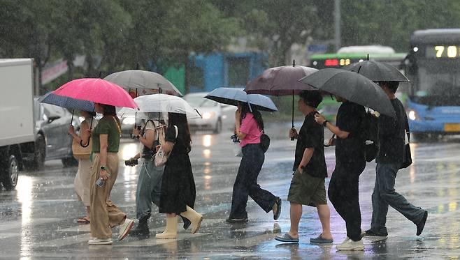 장마가 시작되며 서울 전역에 호우주의보가 내려진 20일 오전 서울 광화문네거리에서 우산을 쓴 시민들이 출근하고 있다./뉴스1