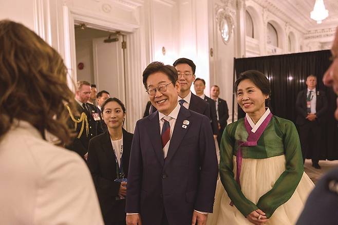 주요 7개국(G7) 초청국 리셉션에서 참석자들과 대화를 나누고 있는 이 대통령과 한복을 입은 김혜경 여사. 사진 뉴시스