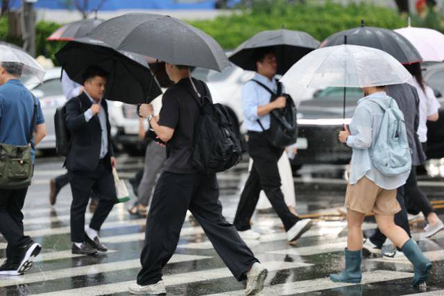 전국에 본격적인 장마가 시작되면서 수도권 등 일부 지역에선 21일까지 최대 150mm 이상의 많은 비가 쏟아지겠다. 사진은 20일 서울 광화문네거리에서 우산을 쓴 시민들이 출근하는 모습. 뉴스1