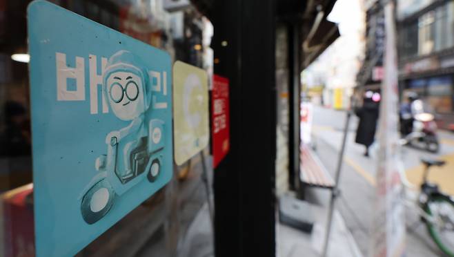 지난 19일 우아한형제들은 더불어민주당 을지키는민생실천위원회 중재로 전국가맹점주협의회, 공정한플랫폼을위한사장협회 등 입점업주단체와 진행하고 있는 사회적 대화에서 1만원 이하 주문에 대한 중개수수료 전액 면제와 배달비 차등 지원 등 추가 상생방안에 대해 중간 합의했다. 이에 따라 현재 1만2000~1만8000원 사이로 책정 돼 있는 최소주문금액이 더 낮아질 것으로 기대된다. 서울의 한 음식점에 배달앱 배달의민족 스티커가 붙어 있다.  /사진=뉴스1