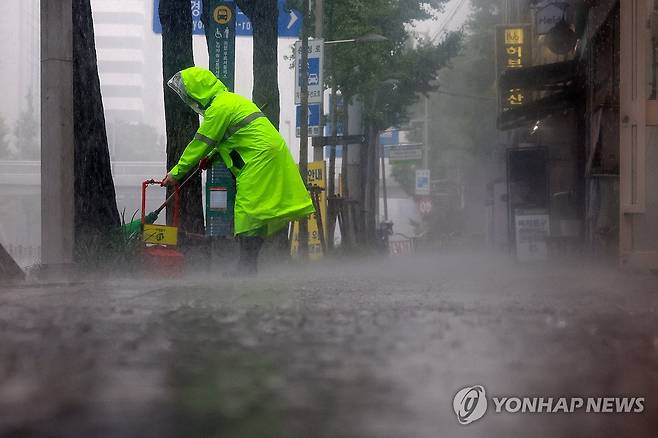비 내려도 묵묵히 (서울=연합뉴스) 신현우 기자 = 16일 폭우가 쏟아진 서울 서대문구에서 환경미화원이 인도를 청소하고 있다. 2025.6.16 nowwego@yna.co.kr