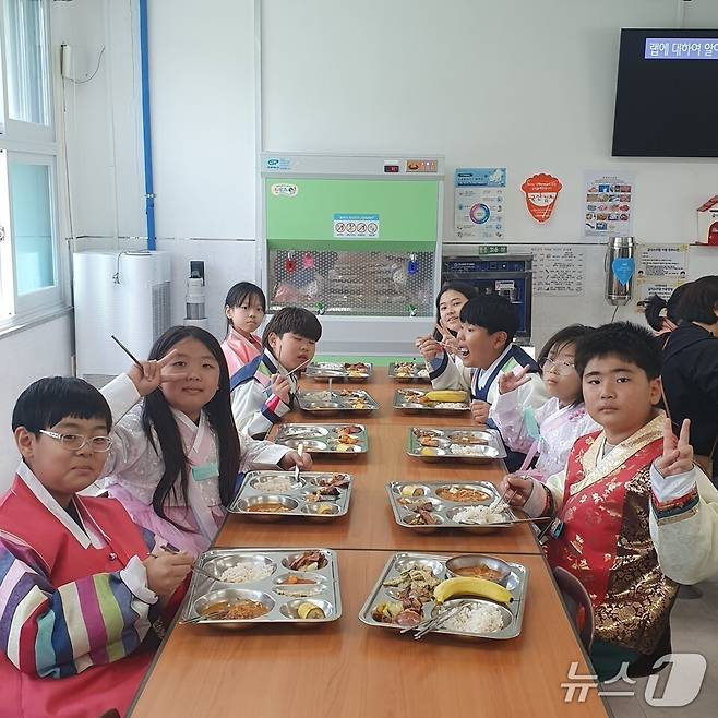 학생들이  한복을 차려입고 급식을 먹으며 포즈를 취하고 있다. (전남도교육청 제공, 재판매 및 DB 금지)/뉴스1
