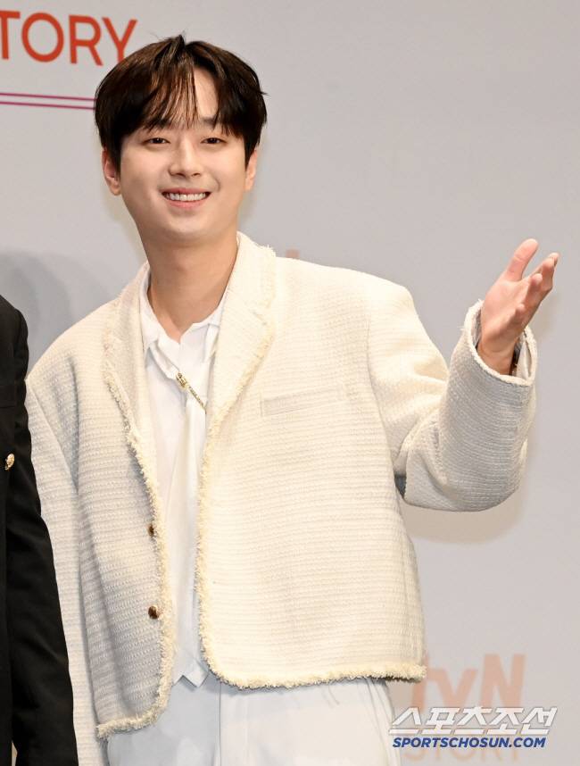 이찬원이 공식 행사에서 환하게 웃으며 손을 흔드는 모습, 흰 재킷 착용