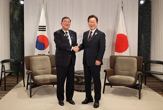 이재명 대통령이 17일(현지시간) 캐나다 앨버타주 캐내내스키스 주요 7개국(G7) 정상회의장에서 열린 한일 정상회담에서 이시바 시게루 일본 총리와 악수하며 기념촬영을 하고 있다. ⓒ연합뉴스