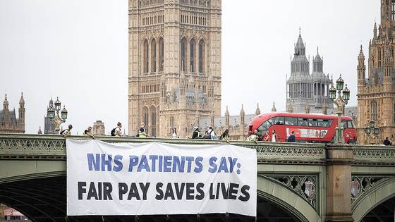 2024년 6월 27일 영국 런던 웨스트민스터 다리에서 한 시민단체가 임금 인상을 요구하는 의사들의 파업을 지지하는 현수막을 걸고 있다. AFP=연합뉴스