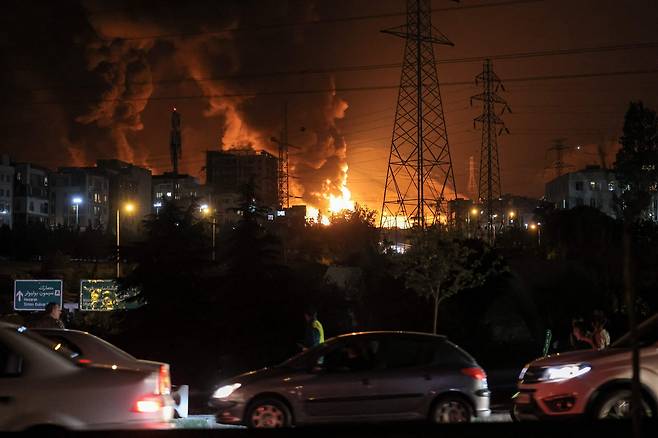 15일(현지시간) 이란 테헤란 북서쪽 샤란의 석유 매장지 근처에서 화재가 발생하자 차량들이 고속도로를 막고 있다. [AP]