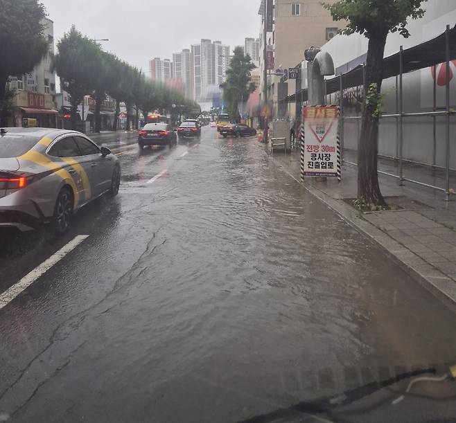 정체전선이 남하해 폭우가 쏟아지는 21일 오전 광주 동구 금남로 한 도로가 빗물에 잠겨있다. [연합]