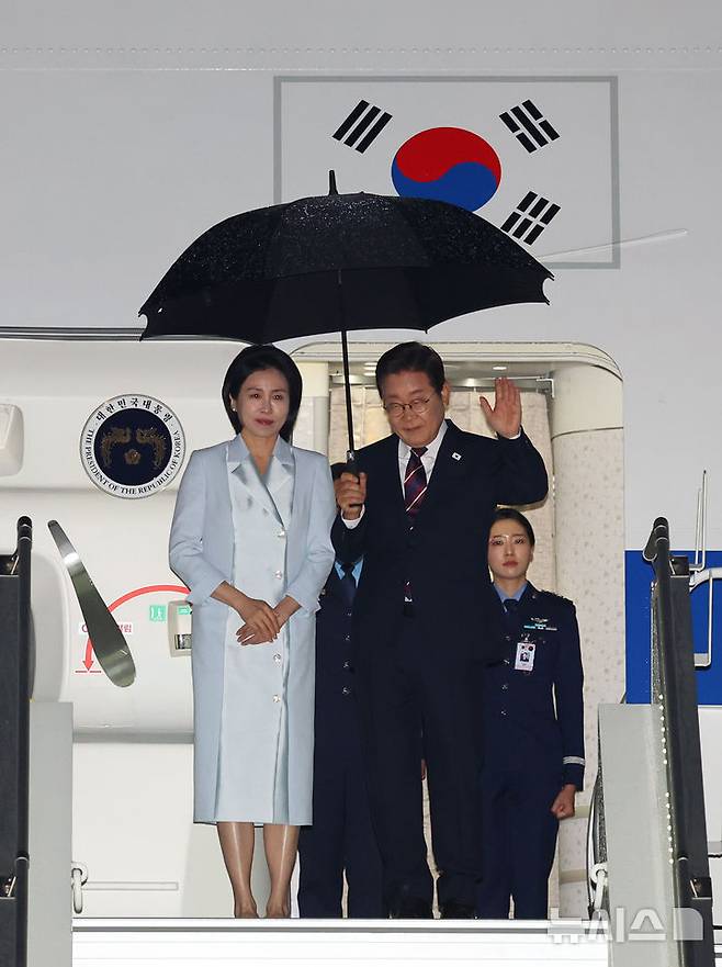 [캘거리=뉴시스] 최진석 기자 = 주요 7개국(G7) 정상회의 참석을 마친 이재명 대통령과 부인 김혜경 여사가 17일(현지 시간) 캐나다 앨버타주 캘거리국제공항에 도착해 공군 1호기에 탑승하며 손을 흔들고 있다. 2025.06.18. myjs@newsis.com