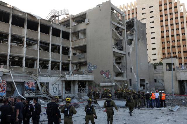 20일(현지 시간) 이스라엘 하이파 지역에서 이란의 미사일 공격에 무너진 건물 앞으로 구조대가 모여있다. 로이터연합뉴스