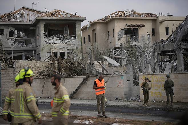 이란이 발사한 탄도미사일이 떨어진 22일 이스라엘 중부 네스치오나에서 구조대원과 소방대원이 피해 상황을 점검하고 있다. 이번 공격은 미국의 이란 핵시설 공습에 대한 보복 차원에서 이뤄졌다. /AP 연합뉴스