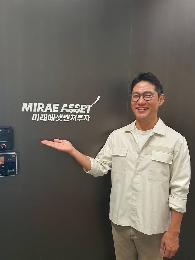 김경모 상무가 회사 로고 앞에서 포즈를 취하고 있다. 윤현주 기자