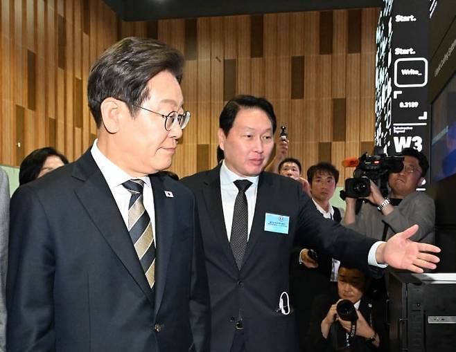 이재명 대통령이 6월 20일 울산전시컨벤션센터에서 열린 인공지능(AI) 글로벌 협력 기업 간담회를 마친 뒤 AI 제품·서비스 시연을 참관하며 최태원 SK그룹 회장의 설명을 듣고 있다. 사진=대통령실사진기자단