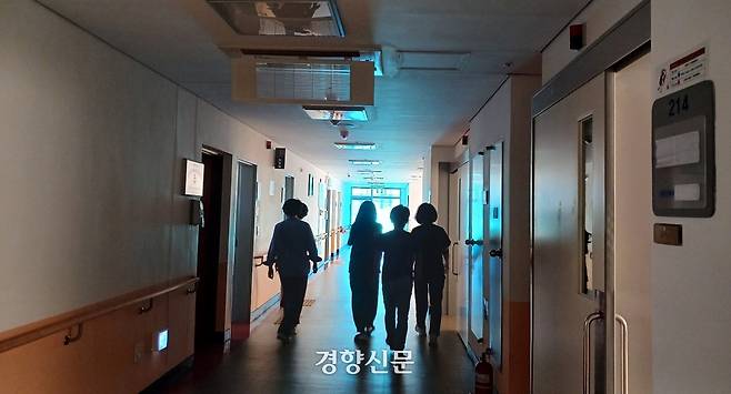 지난 4일 광주 남구 광주시립제2요양병원 건물에서 폐업 1년6개월 동안 병원을 지키고 있는 직원들이 불꺼진 복도를 지나가고 있다. 강현석 기자