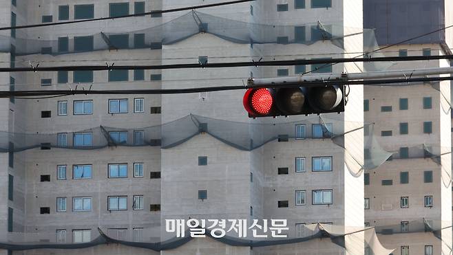 아파트 건설현장 앞 도로 신호등에 빨간불이 들어와 있다. [이승환 기자]