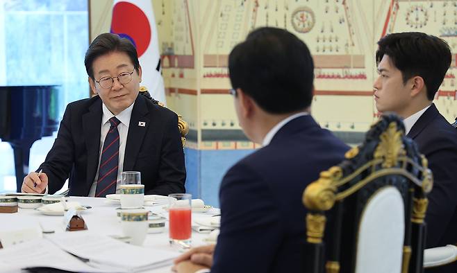 이재명 대통령이 22일 한남동 관저에서 열린 여야 지도부와의 오찬에서 국민의힘 송언석 원내대표(뒷모습)의 발언을 듣고 있다. 오른쪽은 김용태 비대위원장. 연합뉴스