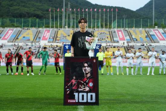 K리그 통산 100경기 출장을 달성한 경남FC 이강희가 수원전에 앞서 꽃다발과 100경기 출전 기념 액자를 받고 기념촬영을 하고 있다. 사진=경남FC