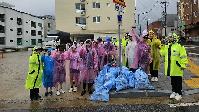 장곡중학교 학생과 가족, 석적자율방범대원들이 칠곡군 쓰리 GO 사업의 일환으로 진행된 학교주변 일대 쓰레기를 수거한 후 기념사진을 촬영하고 있다. /칠곡교육지원청 제공