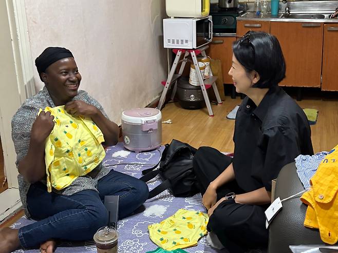 9일 경기 안산시 단원구 선부동의 한 빌라 반지하에서 김예분 더브릿지 단장이 우간다 출신의 마야에게 아동복을 선물하고 있다./최혜승기자